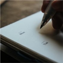 Image Closeup of a hand writing with a pen and paper