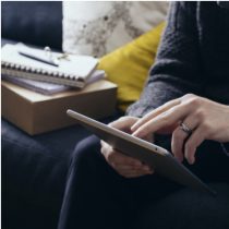 Image Closeup of person sitting down working on a tablet